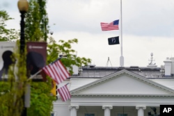 The American flag flies at half-staff over the White House in Washington, April 16, 2021.