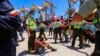 La policía chilena protege a un migrante venezolano que fue atacado por un manifestante que marchaba contra la migración ilegal, en una playa de Iquique, Chile, el 30 de enero de 2022. 