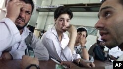 Afghan men listen as a post office worker explains how to use their mobile phones at the Kabul post office. (file) 