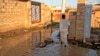 A man walks through a flooded street in the al-Kalakla neighborhood of Sudan's capital, Khartoum, Sept. 7, 2021. 