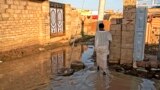 A man walks through a flooded street in the al-Kalakla neighborhood of Sudan's capital, Khartoum, Sept. 7, 2021. 