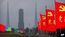 Bendera-bendera dengan logo Partai Komunis berkibar dekat lokasi peluncuran di Peluncuran Antariksa Wenchang di Provinsi Hainan, 23 November 2020. China meluncurkan pesawat antariksa nirawak ke Bulan untuk memngambil sampel tanah.