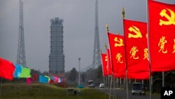 Flags with the logo of the Communist Party of China fly in the breeze near a launch pad at the Wenchang Space Launch Site in Wenchang in southern China's Hainan province, Monday, Nov. 23, 2020. 