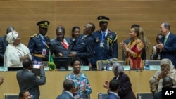 African Union chairman Chadian President Idriss Deby, fourth left, receives the instruments of office from his predecessor Zimbabwean President, Robert Mugabe, as AU Commission Chairperson Nkosazana Dlamini Zuma, left, African Union chairman Chadian President Idriss Deby, fourth left, receives the instruments of office from his predecessor Zimbabwean President, Robert Mugabe, third left in red tie, as African Union Commission Chairperson Nkosazana Dlamini Zuma, left, and UN Secretary General , Ban Ki-moon, right, watches, in Addis Ababa.
