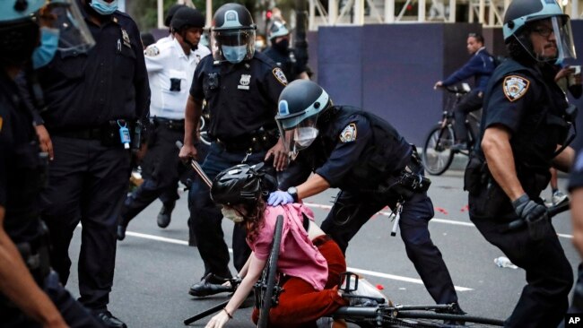 In this June 3, 2020 file photo, a protester is arrested by NYPD officers for violating curfew beside New York's iconic Plaza Hotel, following the death of George Floyd