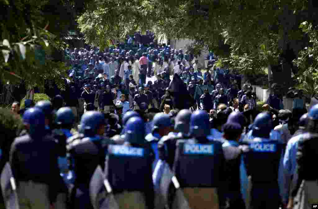 Pakistani police officers stand guard as Pakistani lawyers chant slogans near the area that houses the U.S. Embassy and other foreign missions in Islamabad, Pakistan, September 19, 2012.