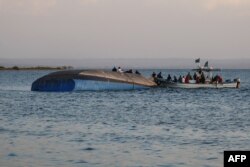 Investigators examine the capsized ferry MV Nyerere, in Lake Victoria, Tanzania, Sept. 21, 2018.