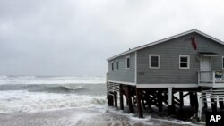 Waves wash ashore hitting a house as winds and storm surge from Tropical Storm Maria lash North Carolinas Outer Banks as the storm moves by well off-shore on Wednesday, Sept. 27, 2017. Dare County officials said the high tide flooded some roads in the area and travel is hazardous.