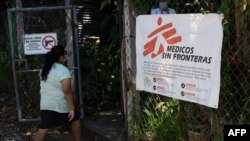 Una residente llega para una consulta médica en una clínica de la organización Médicos sin Fronteras (MSF) instalada en la comunidad del 1 de diciembre con un letrero que dice "Zona libre de armas".