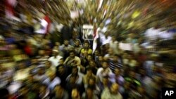 In this zoom effect photo taken with a slow shutter speed, supporters of Egypt's ousted President Mohammed Morsi gather during a demonstration in front of Cairo University, where protesters have installed their camp in Giza, southwest of Cairo, Egypt, Jul