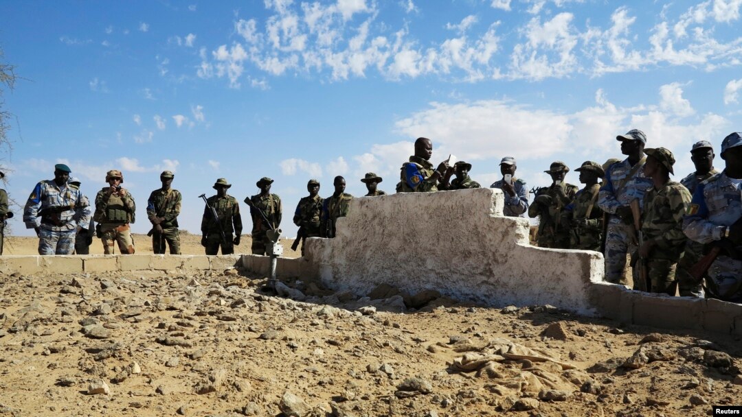 Tentara Mali dan Tentara Prancis berdiri di dekat kuburan masal di Aguelhok, Mali, 4/1/ 2014.