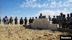 Tentara Mali dan Tentara Prancis berdiri di dekat kuburan masal di Aguelhok, Mali, 4/1/ 2014.