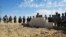 Malian and French soldiers stand next to a mass grave in Aguelhok, Mali, January 24, 2014.