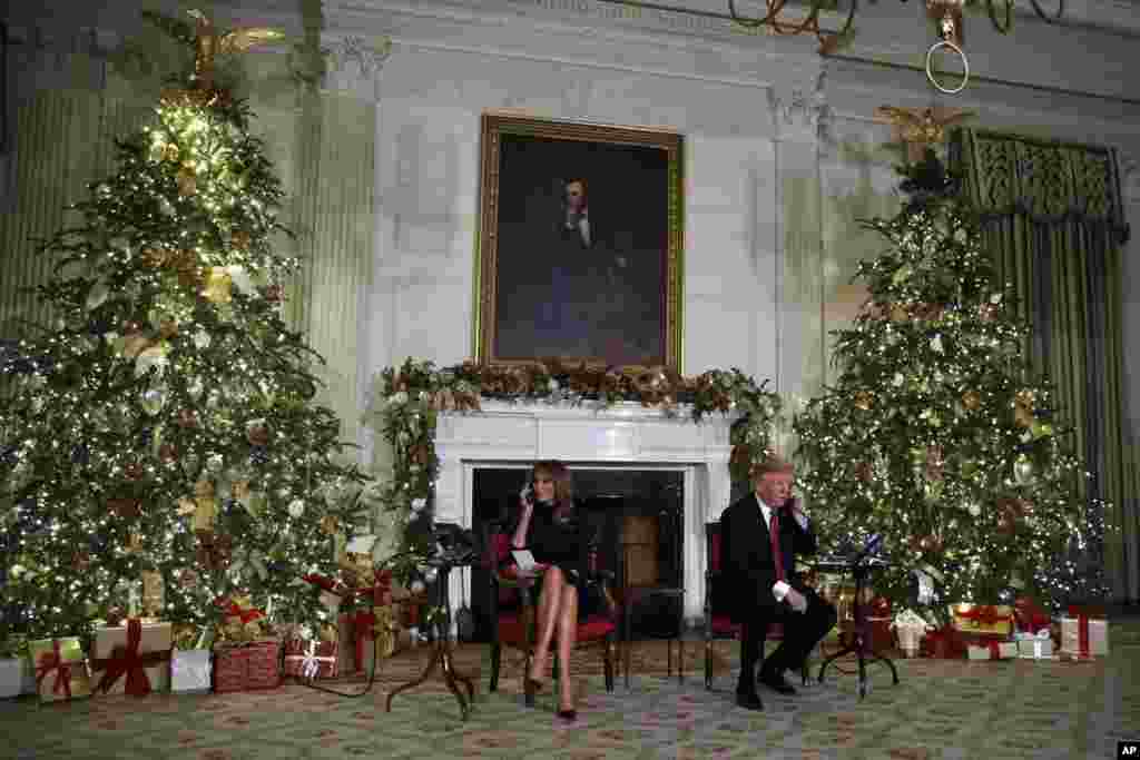 President Donald Trump and first lady Melania Trump speak on the phone at the White House, sharing updates to track Santa&#39;s movements from the North American Aerospace Defense Command (NORAD) Santa Tracker on Christmas Eve, Dec. 24, 2018.