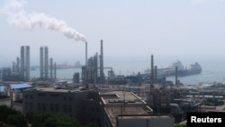 FILE - A refinery is seen near the downtown of Dalian in Liaoning province, China July 17, 2018. REUTERS/Chen Aizhu