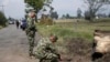 ARCHIVO - Soldados colombianos inspeccionan el lugar donde explotó una pequeña bomba dirigida a un autobús que transportaba personal de la Armada cerca del aeropuerto de Guaymaral, en Bogotá, Colombia, el 7 de marzo de 2016.