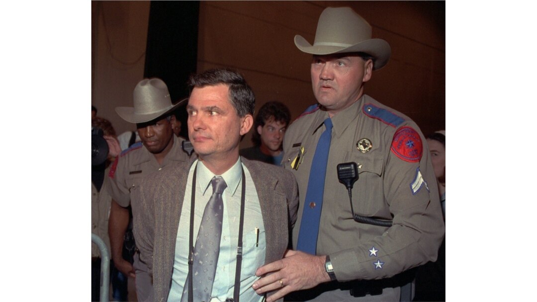 FILE - Texas Department of Public safety officers escort Louis Beam away from a March 18, 1993, Branch Davidian news briefing with the FBI and ATF in Waco, Texas.