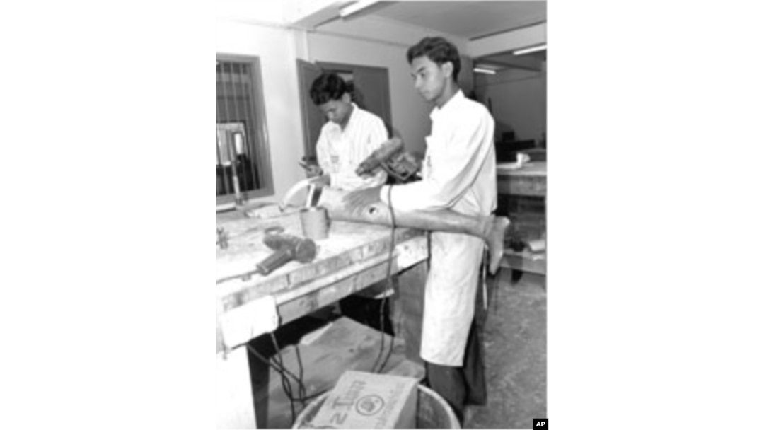 Technicians in Cambodia manufacture prosthetic leg for use by a landmine survivor