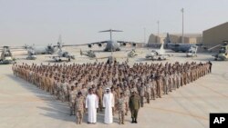 In this Sept. 11, 2017 photo released by Qatar News Agency, the Qatari Emir Sheikh Tamim bin Hamad Al Thani, centre front, poses for a photo with Emiri Air Force at al-Udeid Air Base in Doha, Qatar. 