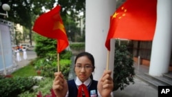 Học sinh Việt Nam cầm cờ Trung Quốc đón ông Tập Cận Bình (ảnh tư liệu).