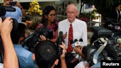 Alan Morison (R), an Australian, and Thai national Chutima Sidasathian, reporters for the Phuketwan news website, speak to media as they arrive to a criminal court in Phuket, April 17, 2014. 