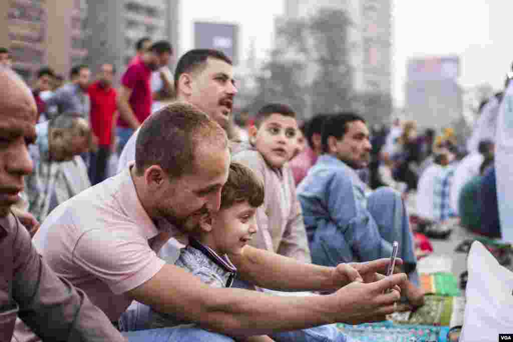 Assem, seorang ayah berusia 32 tahun berfoto selfie dengan anaknya Omar 6 tahun saat sholat Idul Fitri di lapangan Mostafa Mahmoud di Kairo, Mesir, 25 Juni 2017. (H. Elrasam/VOA)