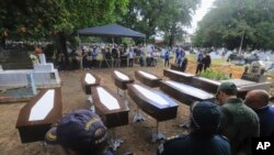 FILE—Authorities stand next to the nine coffins that contain the remains of unidentified migrants, at the Sao Jorge cemetery, in Belem, Para state, Brazil, April 25, 2024.