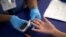 FILE - A person receives a test for diabetes at a free medical clinic in Los Angeles, California, Sept. 11, 2014.  