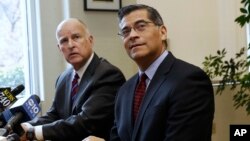 FILE - Gov. Jerry Brown, left, and Rep. Xavier Becerra, D-Calif., the governor's nominee for state attorney general, listen to a reporter's questions in Sacramento, Calif.