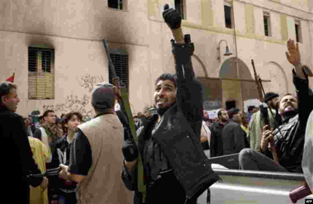 Armed Libyans celebrate in the centre of Benghazi, Libya, Friday, March 18, 2011. The U.N. Security Council voted Thursday to impose a no-fly zone over Libya and authorize "all necessary measures" to protect civilians from attacks by Moammar Gadhafi's for