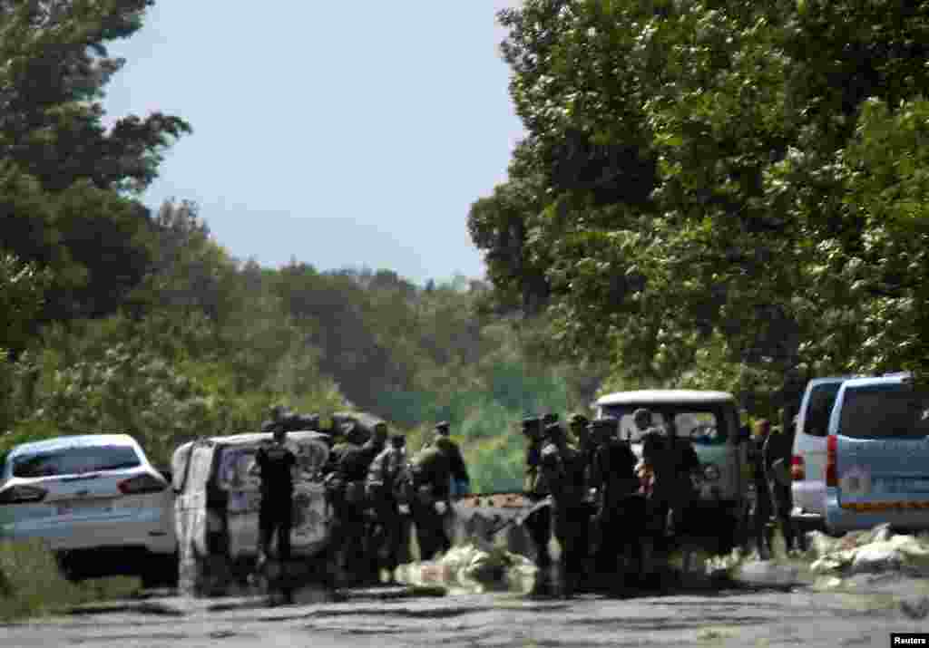 Ukrainian soldiers remove debris from an area where pro-Russian rebels killed Ukrainian servicemen on the outskirts of the eastern Ukrainian town of Volnovakha, south of Donetsk, May 22, 2014.