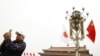 A man uses his mobile phone under Chinese and Japanese flags in front of the Tiananmen Gate ahead of Japan's Prime Minister Shinzo Abe's visit, in Beijing, Oct. 25, 2018.