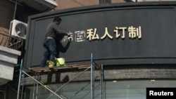 上海一名工人移走商店招牌上的“韩国”两字（2017年3月15日照片）