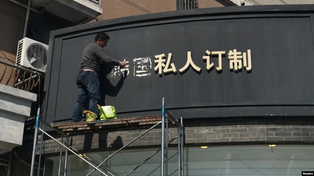 上海一名工人移走商店招牌上的“韩国”两字（2017年3月15日照片）