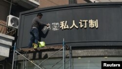 上海一名工人移走商店招牌上的“韩国”两字（2017年3月15日照片）