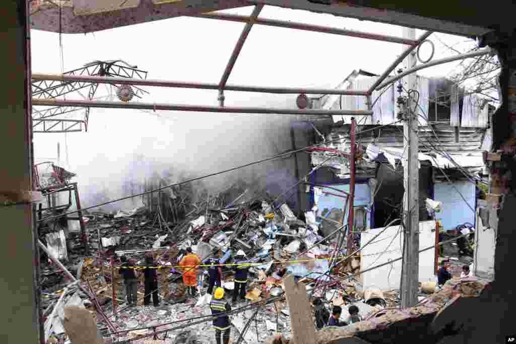 Thai firefighters fight the blaze after an explosion at a scrap shop in Bangkok, Thailand, April 2, 2014. Workers at the scrap shop in Thailand's capital on Wednesday accidentally detonated a large bomb believed to have been dropped during World War II, k