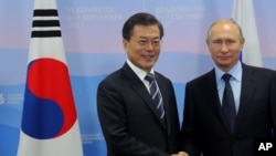 Presiden Rusia Vladimir Putin (kanan), berpose dengan Presiden Korea Selatan Moon Jae-in dalam Forum Ekonomi Timur di Vladivostok, Rusia, Rabu, 6 September 2017. (Mikhail Klimentyev, Sputnik, Kremlin Pool Photo via AP)