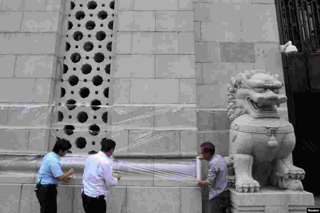 홍콩의 중국인민은행 직원들이 반정부 시위대로부터 은행 건물을 보호하기 위해 플라스틱 필름을 씌우고 있다.