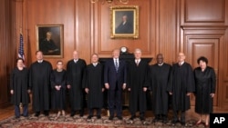 In this image provided by the Supreme Court, President Donald Trump poses with members of the Supreme Court, June 15, 2017, at the court in Washington.