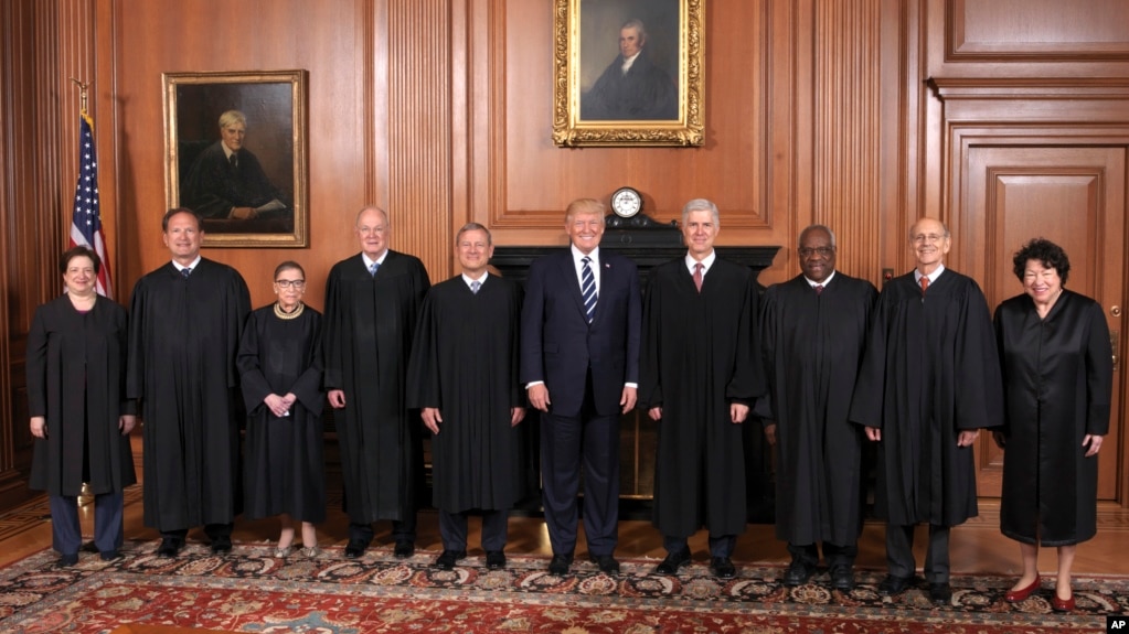 In this image provided by the Supreme Court, President Donald Trump poses with members of the Supreme Court, June 15, 2017, at the court in Washington. 