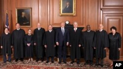 In this image provided by the Supreme Court, President Donald Trump poses with members of the Supreme Court, June 15, 2017, at the court in Washington.