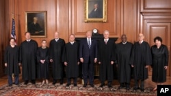 In this image provided by the Supreme Court, President Donald Trump poses with members of the Supreme Court, June 15, 2017, at the court in Washington. 