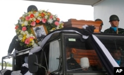 FILE - The body of Saman Gunan, a former Thai navy SEAL, is carried during a repatriation and religious rites ceremony at Chiang Rai Airport in Mae Sai, Chiang Rai province, in Thailand, July 6, 2018.