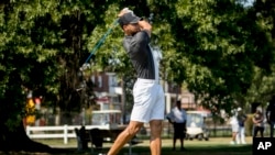 Golden State Warriors guard Stephen Curry tees off at Langston Golf Course in Washington, Monday, Aug. 19, 2019, following an announcement that he would be sponsoring men's and women's golf teams at Howard University. (AP Photo/Andrew Harnik)