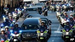 A motorcycle parade follows the hearse carrying the casket of French rock star Johnny Hallyday, down the Champs-Elysees avenue in Paris, Saturday, Dec.9, 2017.