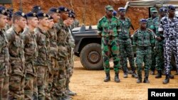 Les soldats français se tiennant près des soldats ivoiriens à Toumodi, lors d'une formation militaire avant le départ des militaires ivoiriens pour le Mali, le 6 avril 2013.
