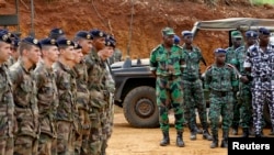 Des soldats français près d'un groupe de militaires ivoiriens, durant une séance de formation, avant le départ des soldats ivoiriens vers le Mali (6 avril 2013)