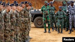 French soldiers stand near Ivorian soldiers in Toumodi, during a military training ahead of the departure of Ivorian soldiers for Mali, Apr. 6, 2013.