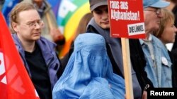 Seorang warga Jerman dengan mengenakan "burqa" memrotes pemberangkatan pasukan Jerman ke Afghanistan dalam aksi unjuk rasa di Berlin (foto: dok).