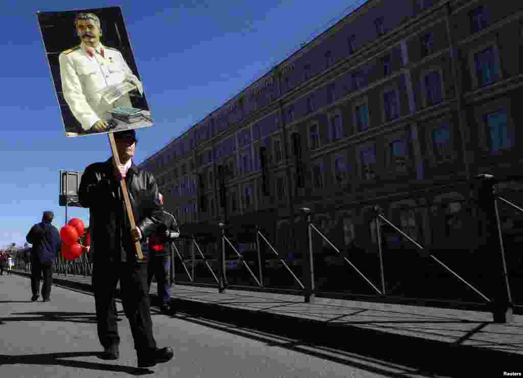 Seorang pria membawa potret mantan diktator Soviet Joseph Stalin dalam perayaan Hari Buruh di St. Petersburg, Rusia (1/5).